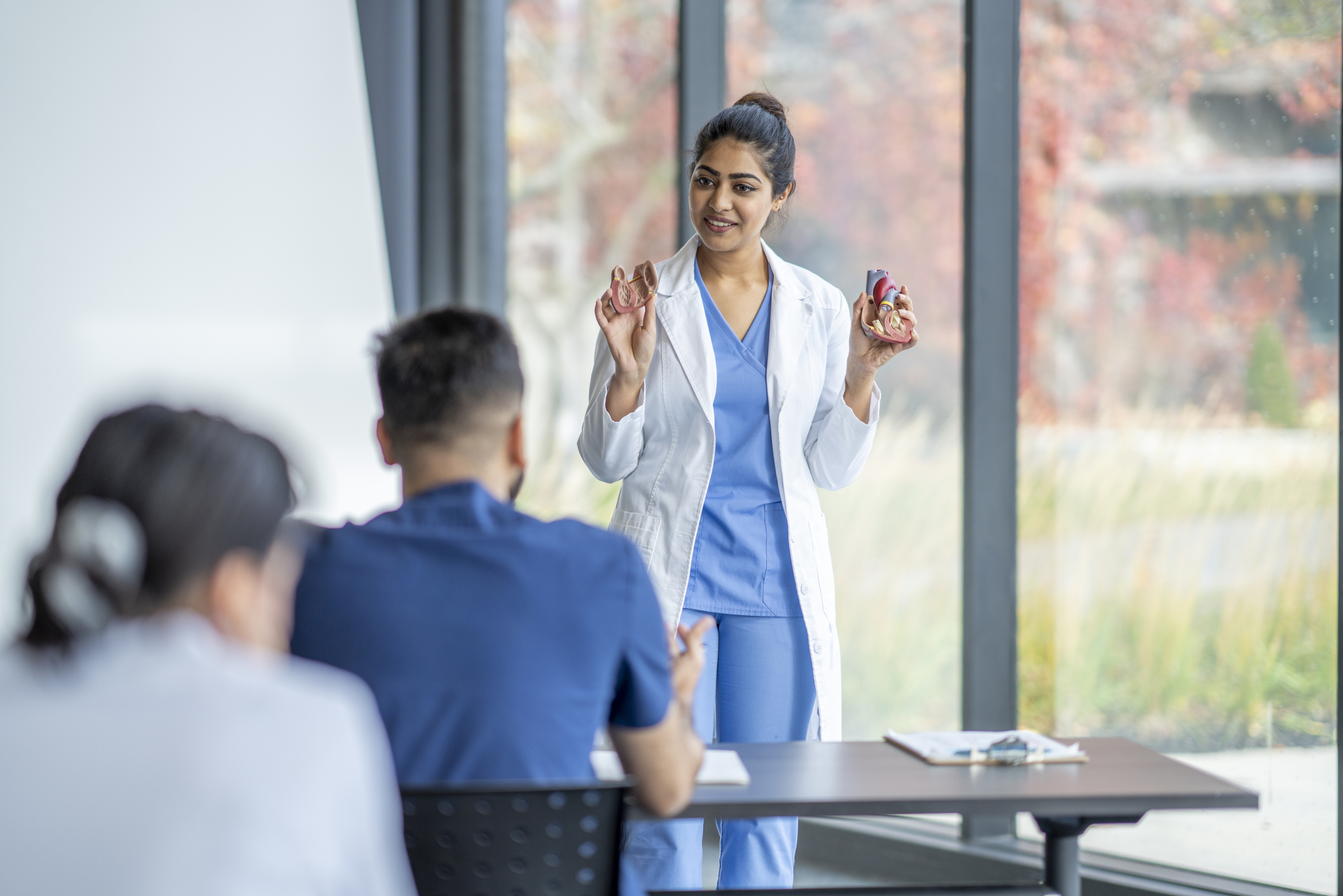 A nurse educator teaches in front of a classroom