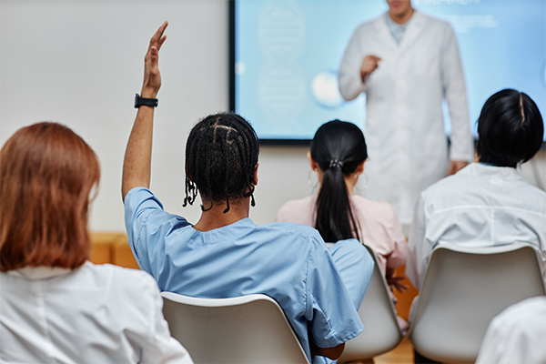 A person raises their hand in a classroom
