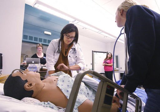 Smiling person at a desk writes in a notebook
