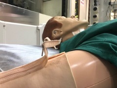 SimMan on a hospital bed with a broken zipper on the antecubital fossa