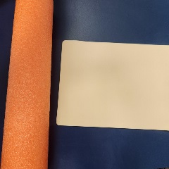 orange pool noodle and tattoo skin on a blue counter