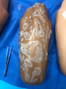 manikin arm covered with dried white liquid school glue with parts of the dried glue chipped off