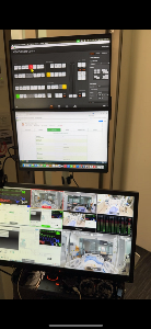 Dual-monitor setup with ATEM Software Control and an electronic medical record on the top screen. Bottom monitor shows ATEM Mini Extreme multiview with live camera feeds of a medical simulation room, patient monitors, and program output.