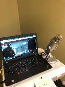 laptop with YouTube on screen and microphone adjacent to the laptop