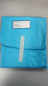 A blue sterile office procedure pack with a white label listing contents: one sterile drape with hole and four sterile towels. A piece of white tape secures the pack.