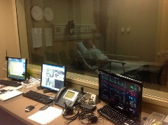 view from a simulation control room looking into a room with a manikin