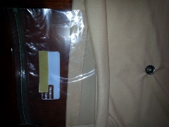 plastic storage bag next to polyester skin colored fabric with button sewed on