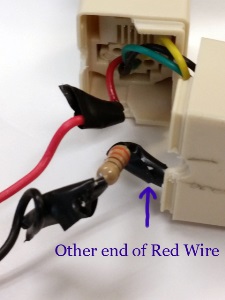 close-up of open phone line coupler with black wire cut and soldered to the other side of the resistor