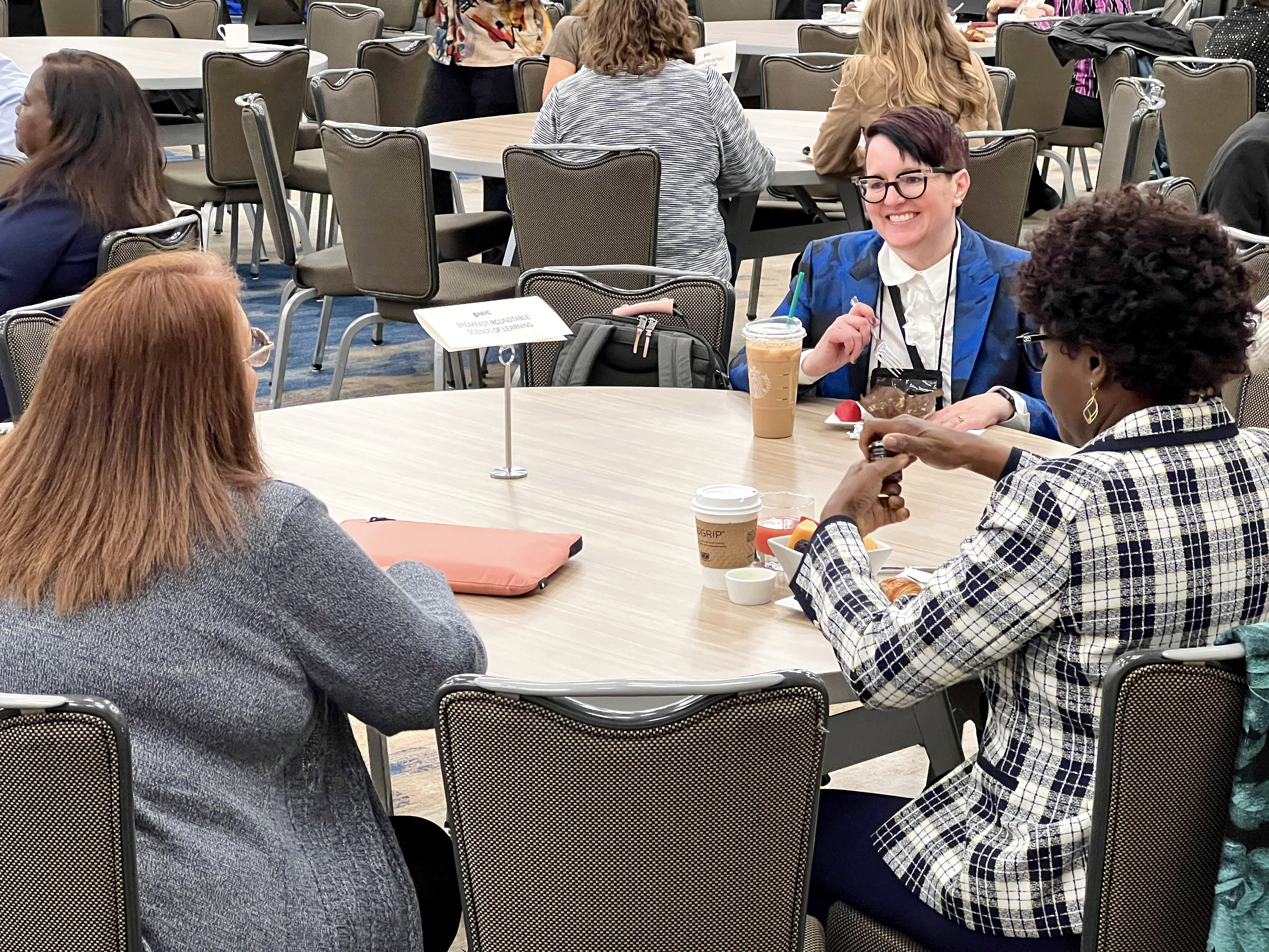 NERC roundtables Nurse educators sit around a table at breakfast discussing pressing issues
