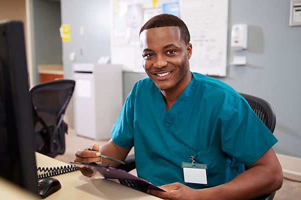 A nurse sits at a computer.