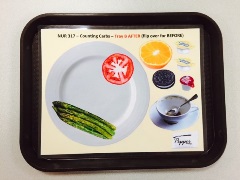 food tray with laminated paper showing a tomato slice and spears of asparagus on a plate with additional food and drinks to the side of the plate