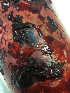 manikin arm with “fresh scab blood” under and around flaps and in holes