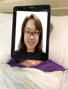 tablet streaming a Zoom video of a woman secured to a manikin face