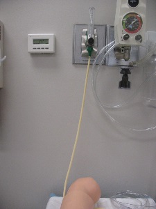 close-up of O2 wall device attached to manikin arm IV