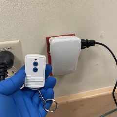 gloved hand holding a wireless on off switch