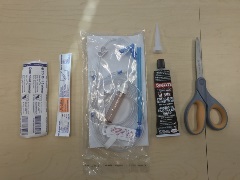 10mL syringe, 14 gauge angiocath, iv tubing, tube of black silicone, scissors
