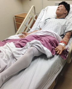 male manikin in hospital bed wearing compression stocks on his legs