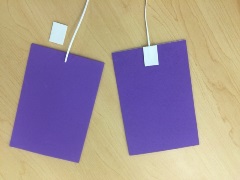 two purple simulated pads with plastic lacing attached to each pad