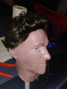 Halloween mask with brown hair wig and a trach