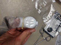 hand holding the manikin lung with filter paper replaced and back snapped shut