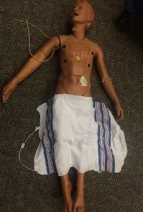 full size manikin with stoma and blanket drapping lower half