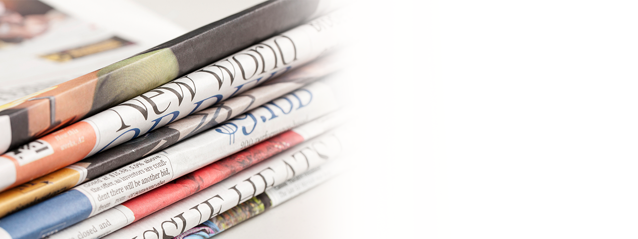 banner-interior-news Newspapers and glasses sit atop an open laptop
